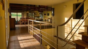 Un intérieur spacieux comprenant un escalier, un coin repas et une vue dégagée sur l’extérieur grâce à une grande fenêtre.
