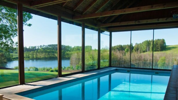 Une piscine avec vue sur un lac et une forêt.