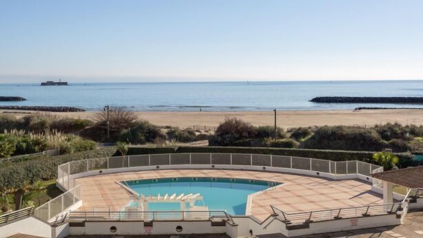 Ein Pool mit Blick auf Strand und Meer.