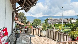 Une terrasse extérieure couverte, agrémentée d’une clôture en bois, d’un banc et d’une table.