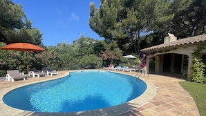 Una piscina con sillas de descanso y una zona de terraza.