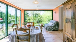 Un coin repas avec une table dressée pour deux personnes, un canapé et un meuble.