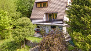 A two-story house with a sloped roof, surrounded by dense greenery. - Partecznik by Interhome (Wisla)