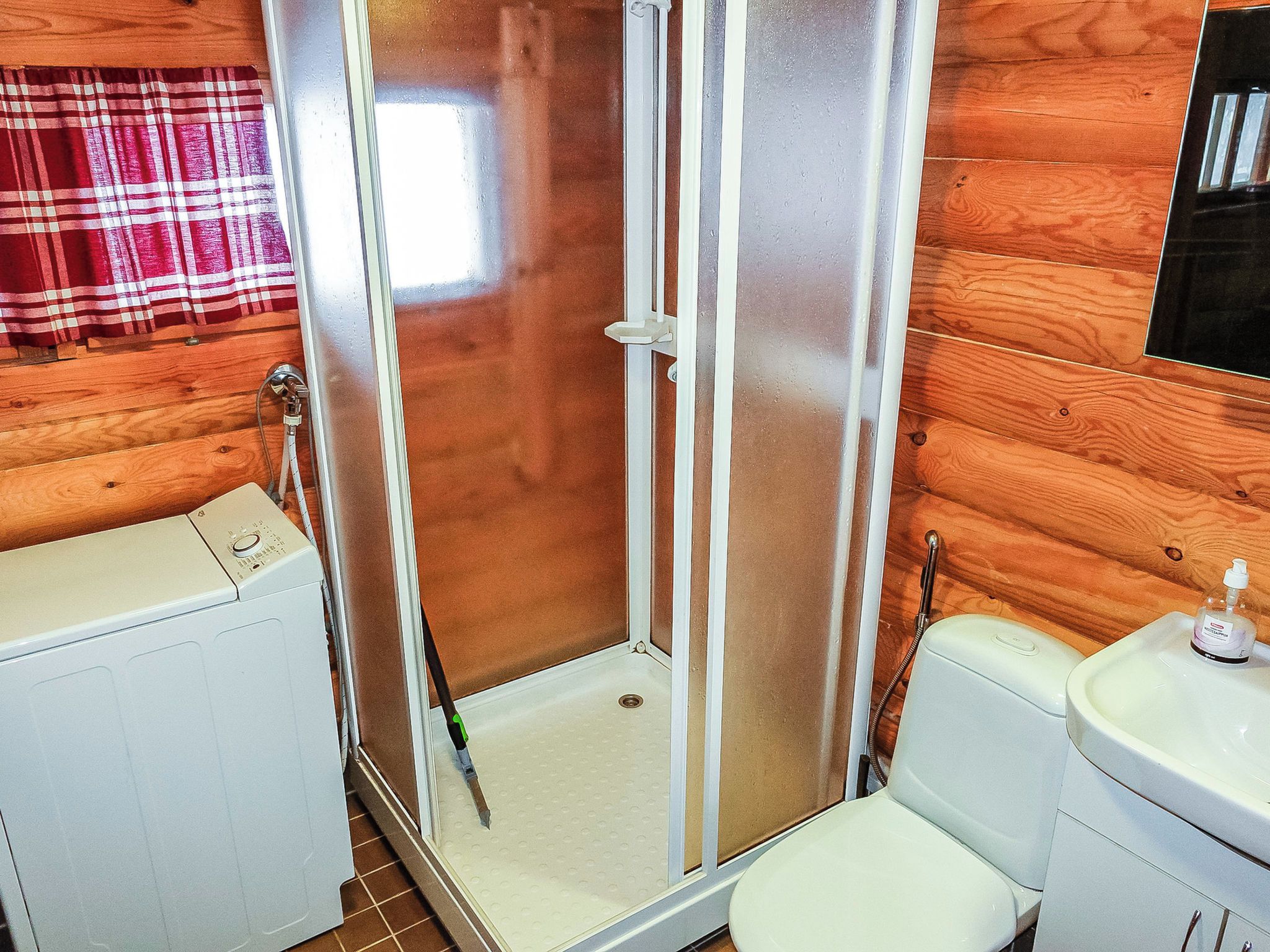 Une salle de bain avec douche, toilettes et lavabo.