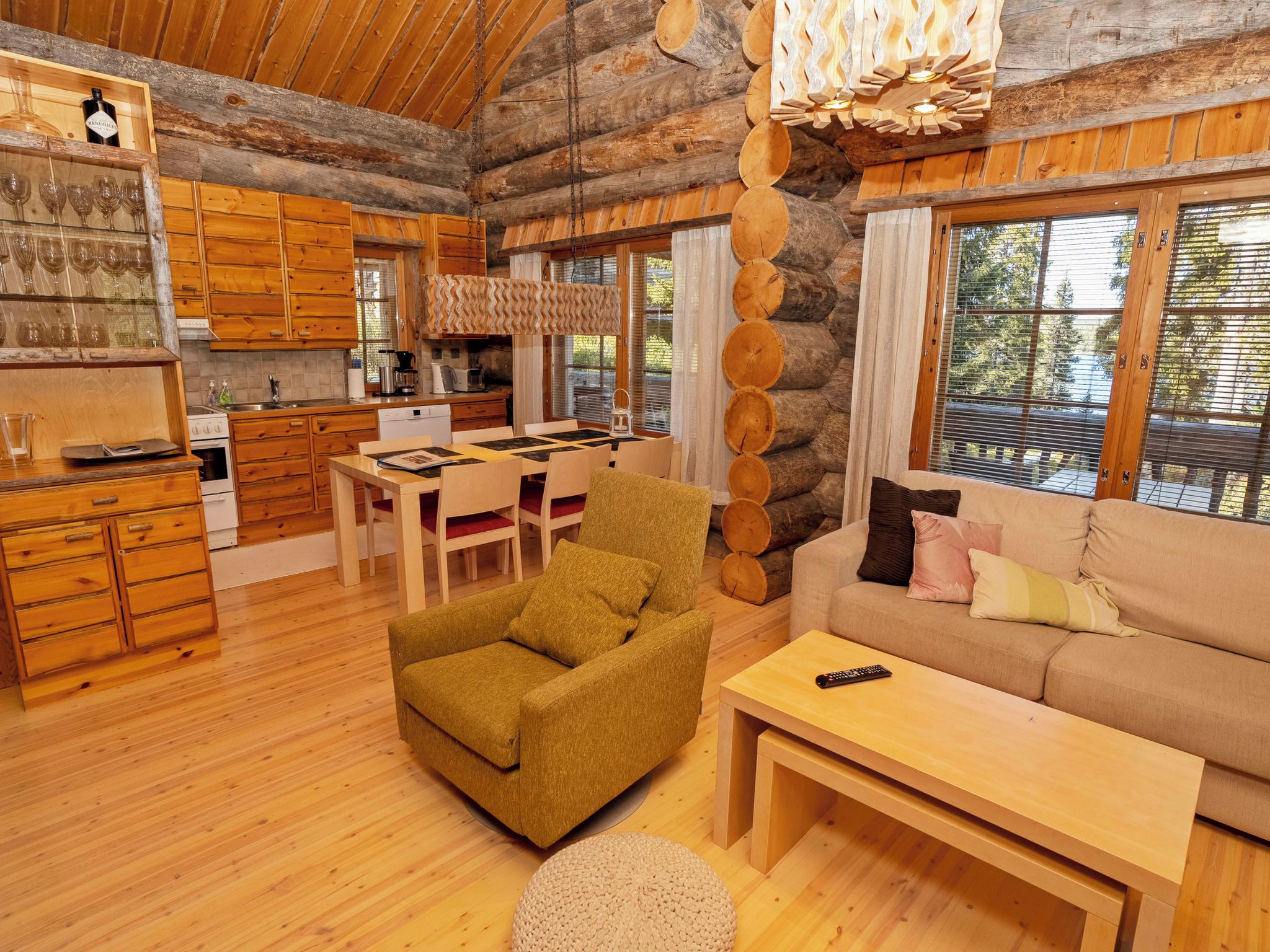 L’intérieur d’un chalet confortable, avec une salle à manger, un canapé et une cuisine.