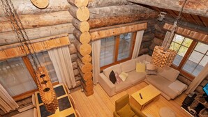 Un interior acogedor de cabaña de madera con un sofá, una mesa de centro y una lámpara colgante.