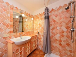 Ein Badezimmer mit Waschbecken, Spiegel und Dusche.