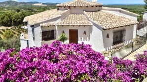 A white building with a tiled roof, surrounded by purple bougainvillea flowers. - Villa Clementina by Interhome (Pego)