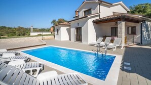 A two-story house with a swimming pool and white lounge chairs. - Dorijano by Interhome (Rabac)
