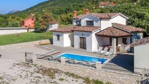 A two-story house with a swimming pool, surrounded by a stone wall and a fenced area. - Dorijano by Interhome (Rabac)