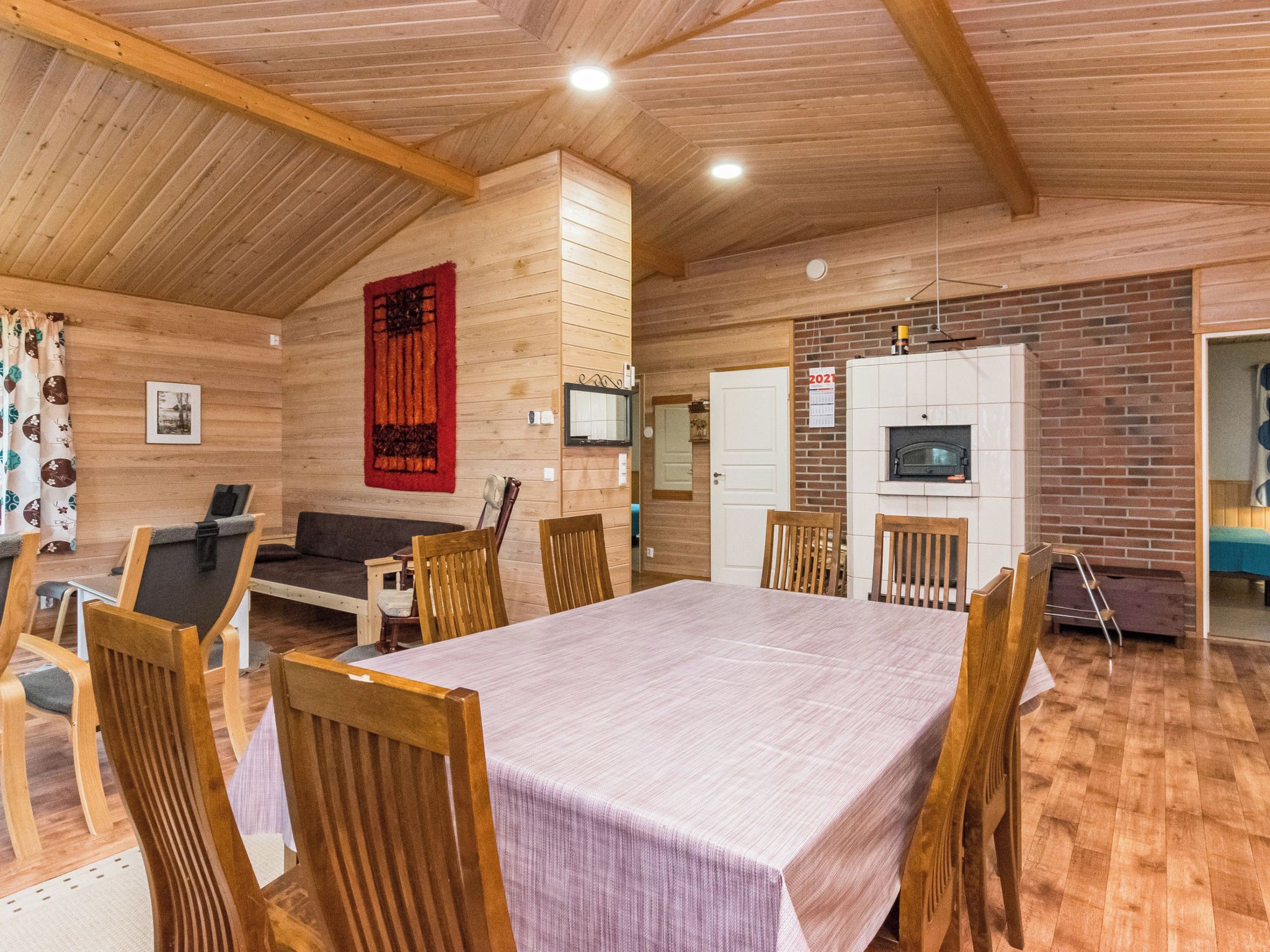 Un interior de madera con una mesa de comedor, sillas, un sofá y una chimenea.