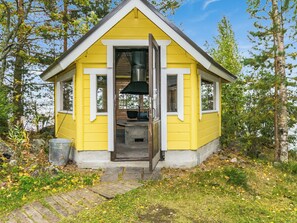 A yellow cabin with a chimney, a window, and a door. - Aurinkoniemi by Interhome (Kesälahti)