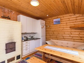 A compact kitchen with white cabinets, a refrigerator, and a wooden ceiling. - Aurinkoniemi by Interhome (Kesälahti)