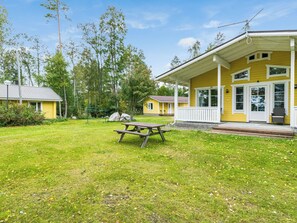 A yellow building with a covered porch and a picnic table in front. - Aurinkoniemi by Interhome (Kesälahti)