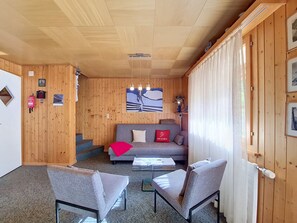 A wooden interior with a sofa, two armchairs, a coffee table, and a painting on the wall. - Allegra by Interhome (St Niklaus)