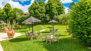 A well-maintained garden with outdoor seating and thatched umbrellas. - Tipologia Trilocale by Interhome (Fucecchio)