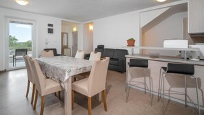 A modern kitchen with a dining area, featuring a marble table, chairs, and a sofa. - Mario 2 by Interhome (Pula/Krnica)