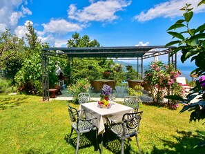 Enjoy a romantic meal under the shade of a pergola with a stunning sea view.