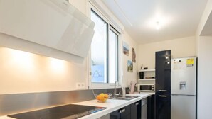 A modern kitchen with a built-in stove, a sink, and a refrigerator.