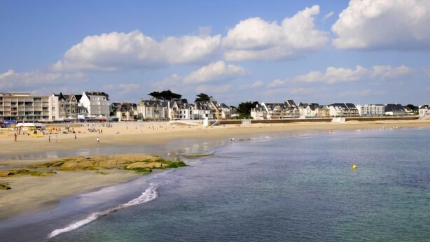 A coastal beach with buildings along the shore.
