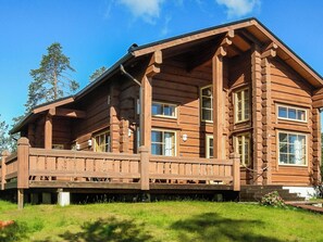 A log cabin with a porch, multiple windows, and a clear sky. - Aamunkoi by Interhome (Inari)