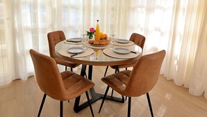 A dining area with a round glass table, six brown chairs, and a white curtain backdrop. - Antoine by Interhome (Marina)