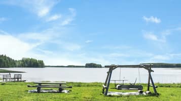 Een picknickplaats aan het meer met banken en een schommel.