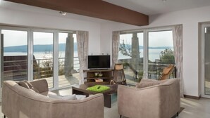 Ein großzügiges Wohnzimmer mit einem großen Fernseher, bequemen Sofas und einem Couchtisch.