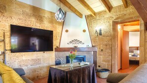 Una sala de estar acogedora con chimenea, un televisor de pantalla plana y asientos cómodos.