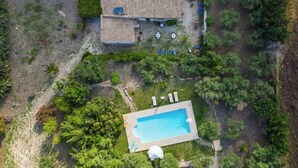 Vista aérea de una propiedad con una casa grande, piscina y jardín.
