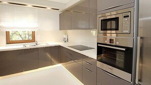 A modern kitchen with stainless steel appliances, a window with a view, and a built-in oven. - Villa Mustra by Interhome (Trogir/Okrug Donji)