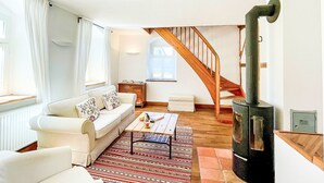 A cozy living room with a sofa, coffee table, and a fireplace.
