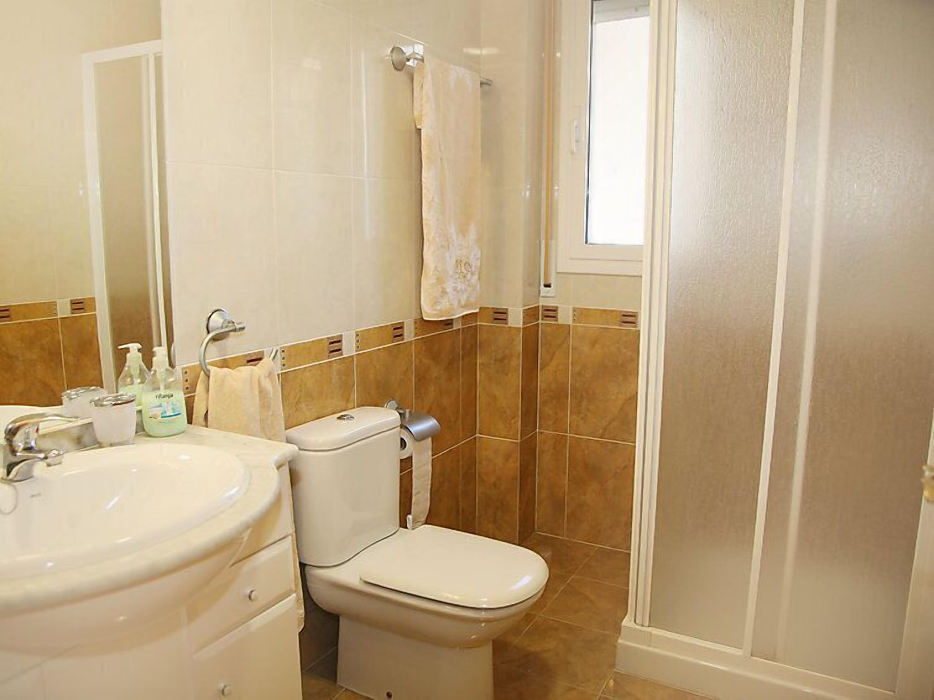 A bathroom with a toilet, sink, and shower.