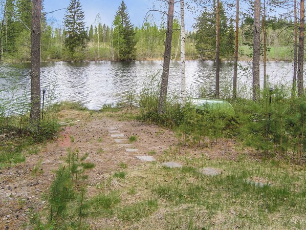 A natural landscape with a lake, a stone path, and surrounding trees. - Yläneuvola lanssi by Interhome (Sotkamo)