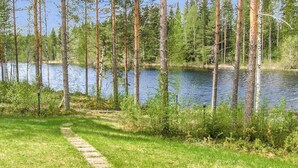 Un sentier de pierres qui mène à un lac bordé de grands arbres.