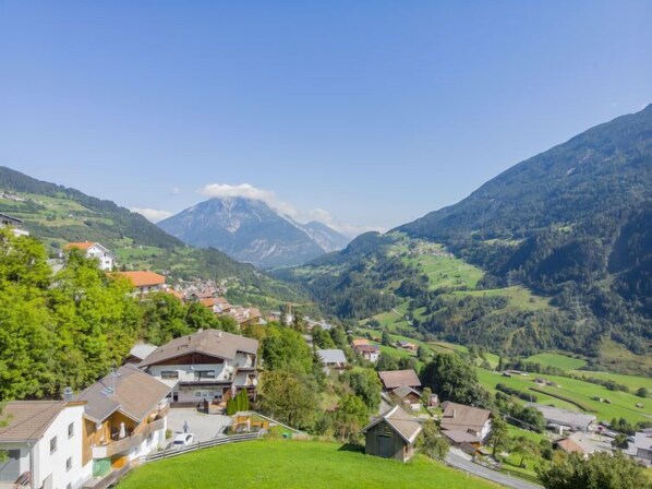 Un village de montagne, avec des maisons et une montagne imposante en arrière-plan.