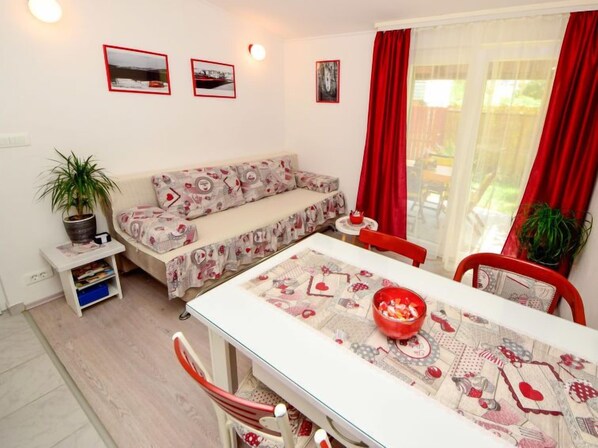 Una sala acogedora con sofá, una mesa de comedor con sillas y una mesita con un cuenco.