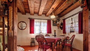 A traditional dining room with a wooden table and chairs, a chandelier, and a fireplace.