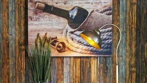 A wooden cabinet with three drawers and a painting of a bottle and a lamp on the wall behind it. - Witthuus-Langeoog by Interhome (Norddeich)