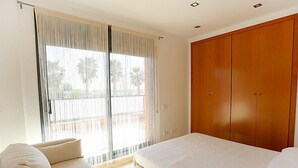 Un dormitorio con cama, sofá y armario.
