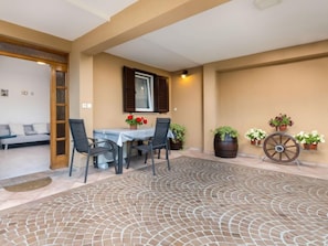 A patio with a mosaic floor, a table with chairs, a sofa, and potted plants. - Apartment Beni by Interhome (Opatija/Pobri)