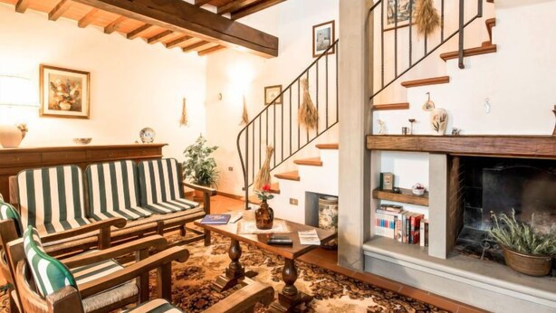 A cozy living room with a wooden bench, a fireplace, and a staircase. - Tribolina by Interhome (Cavriglia)