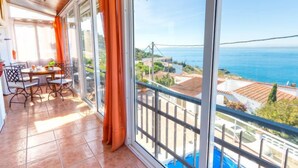 Ein Balkon mit Blick auf das Meer und einen Pool.