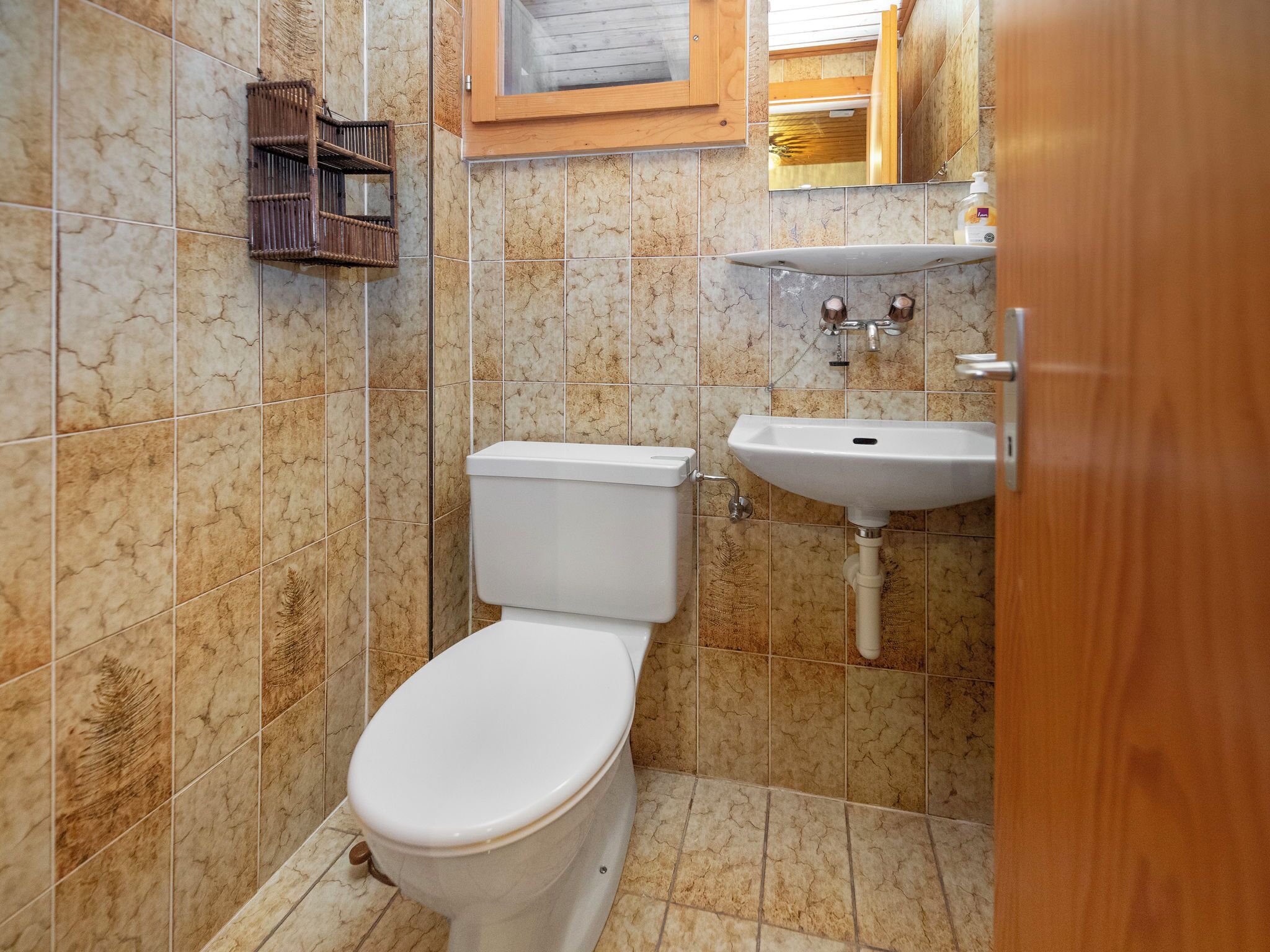 Une salle de bain avec des toilettes, un lavabo et un miroir.