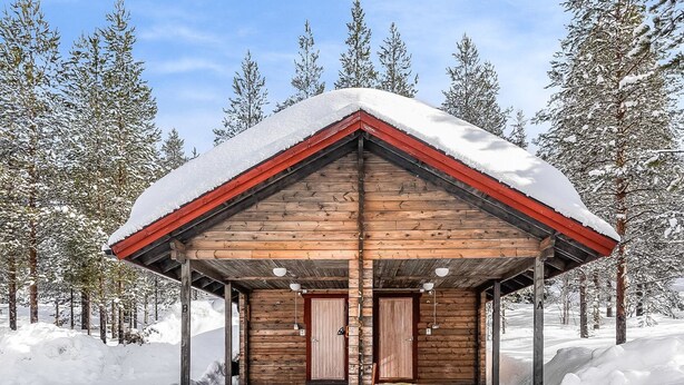 A wooden cabin with a red roof, surrounded by snow-covered trees. - Lustola a by Interhome (Sodankylä)