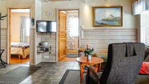 A cozy living room with a television, a painting, and a wooden ceiling. - Lustola a by Interhome (Sodankylä)