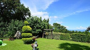 A well-maintained garden with a small statue of a horse, a pergola, and neatly trimmed hedges. - Apartment Zvonko by Interhome (Lovran)