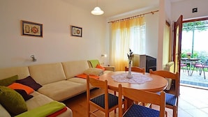 A living room with a sofa, chairs, a table, and a window with curtains. - Apartment Zvonko by Interhome (Lovran)