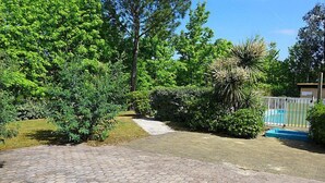 A paved driveway leading to a gated entrance surrounded by lush greenery and trees. - Paradise Océan by Interhome (Capbreton)