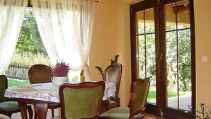 A dining area with a table set for four, surrounded by wooden chairs with green upholstery. - Marylin by Interhome (Marylin)